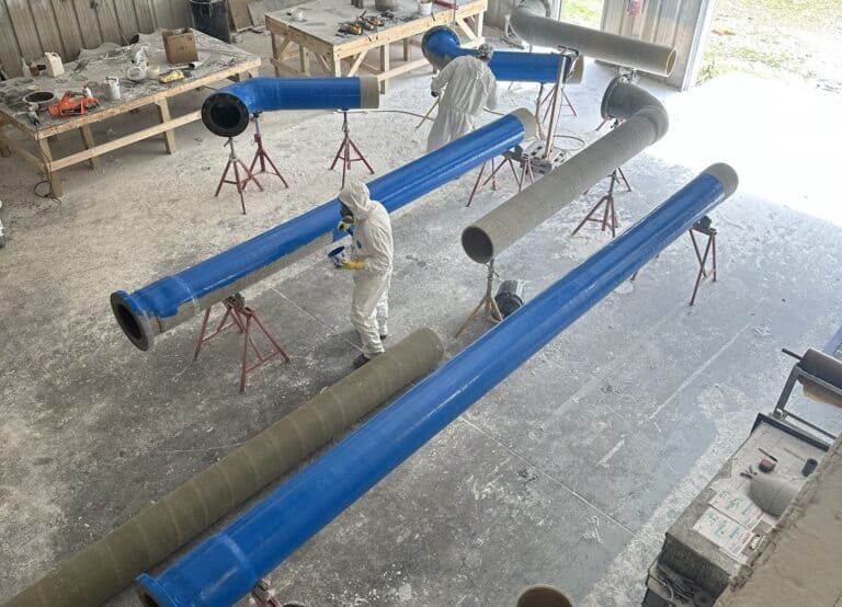 blue fiberglass piping being fabricated in a shop